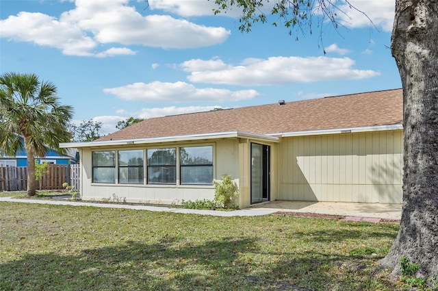 view of front of property with a front lawn, fence, and roof with shingles