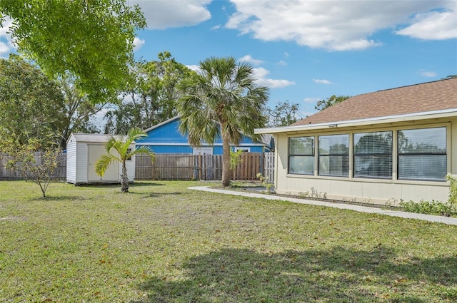 view of yard with an outbuilding, a fenced backyard, and a shed