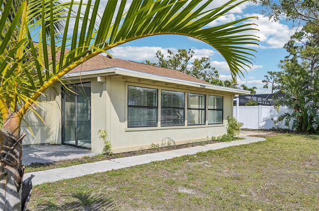 view of home's exterior with a yard and fence