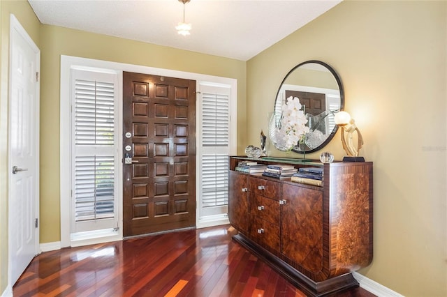 entryway featuring baseboards and dark wood-style flooring