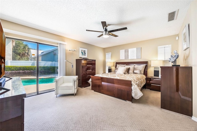 bedroom featuring access to exterior, visible vents, carpet flooring, and a textured ceiling