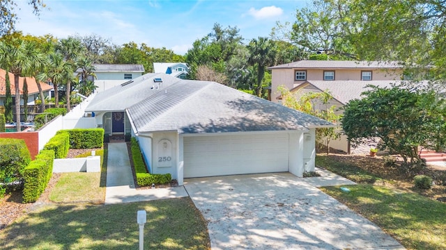 view of front facade with stucco siding, driveway, fence, roof with shingles, and a garage