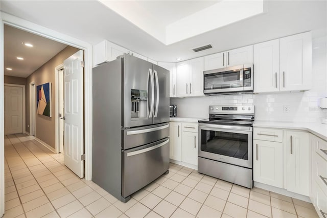 kitchen with visible vents, stainless steel appliances, decorative backsplash, light countertops, and white cabinets