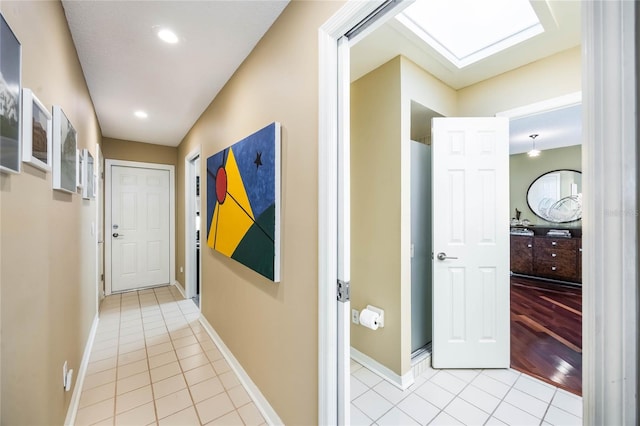 corridor featuring light tile patterned floors, recessed lighting, and baseboards