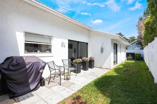 exterior space with stucco siding, a patio, a lawn, and a fenced backyard