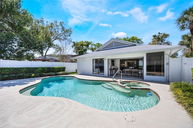 view of pool with a pool with connected hot tub, a patio, and fence