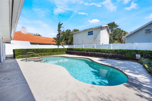 view of swimming pool featuring a patio area, a pool with connected hot tub, and a fenced backyard