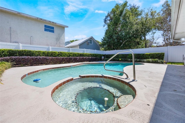 view of pool featuring a patio area, a fenced backyard, and a pool with connected hot tub