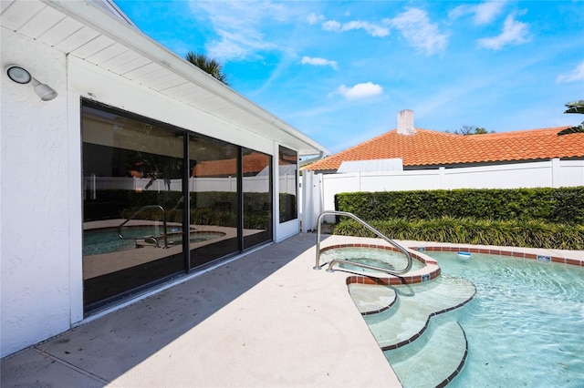 view of pool with a patio area, a fenced in pool, an in ground hot tub, and fence