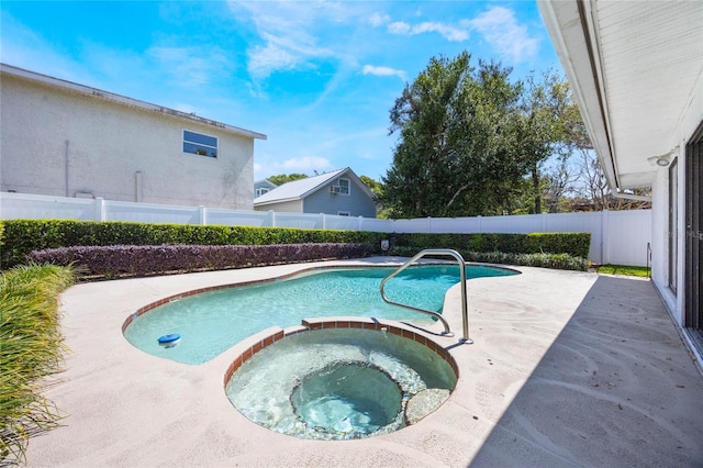 view of swimming pool with a patio area, a pool with connected hot tub, and a fenced backyard