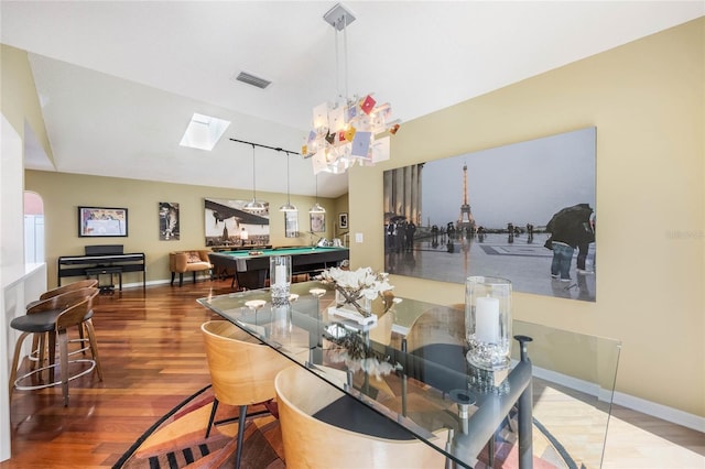 dining space featuring visible vents, pool table, baseboards, vaulted ceiling with skylight, and wood finished floors