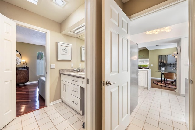 bathroom featuring tile patterned flooring, a textured ceiling, vanity, and baseboards