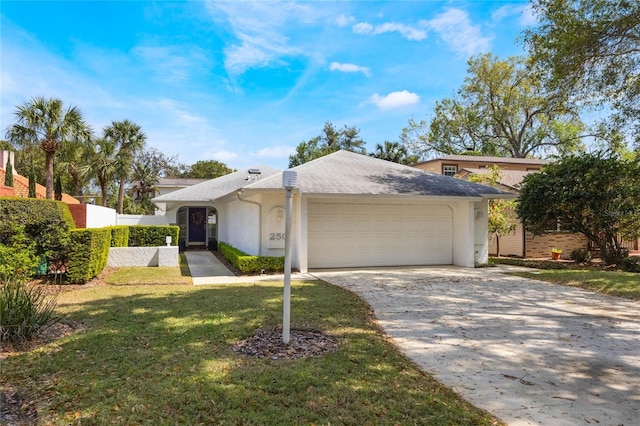 view of front of property with fence, concrete driveway, a front yard, stucco siding, and a garage