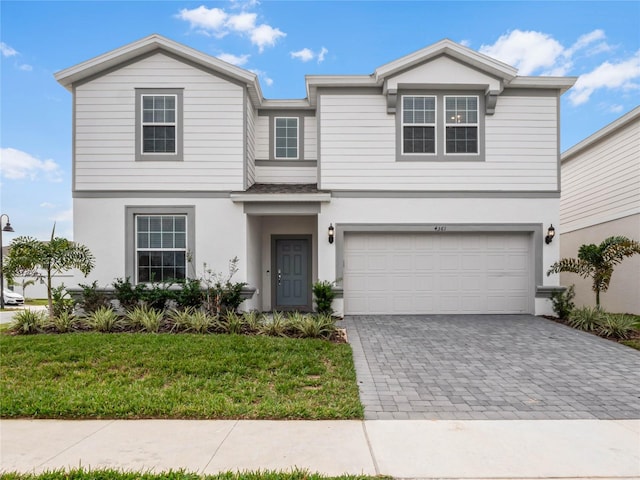 4361 Lana Ave, Davenport, FL 33897 - view of front facade with decorative driveway, a front yard, an attached garage, and stucco siding