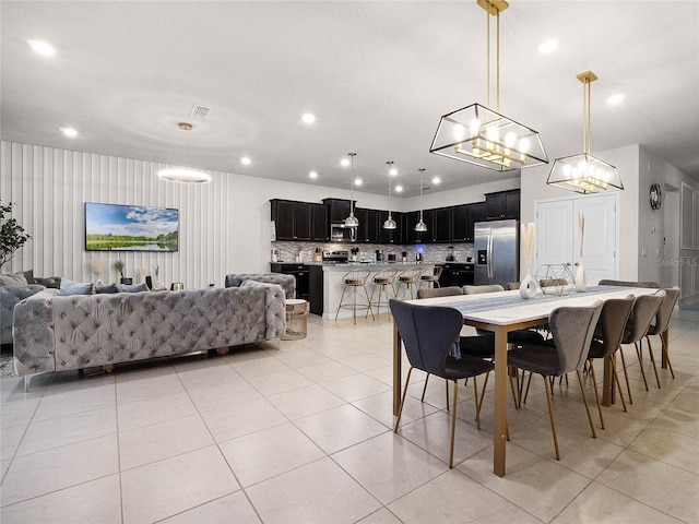 dining space with light tile patterned floors, a notable chandelier, and recessed lighting