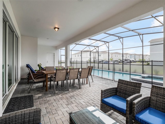 view of patio / terrace featuring outdoor dining space, an in ground hot tub, an outdoor pool, a lanai, and a residential view