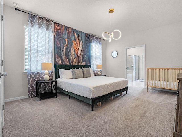 carpeted bedroom featuring baseboards, multiple windows, and ensuite bathroom