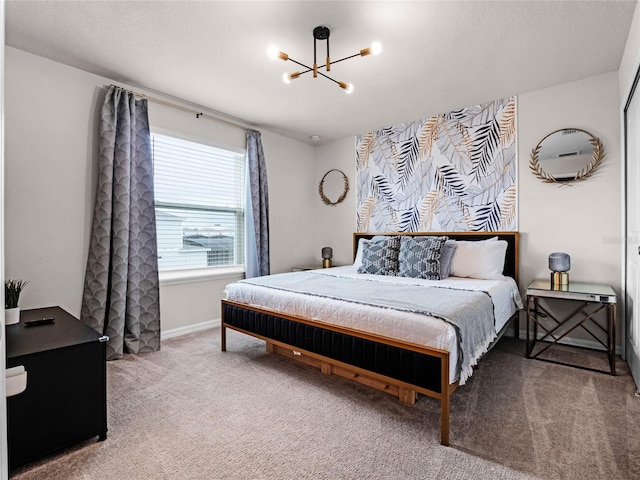 carpeted bedroom featuring a notable chandelier and baseboards