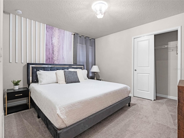 carpeted bedroom featuring a closet, a textured ceiling, and baseboards