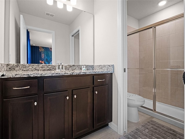 bathroom with vanity, visible vents, tile patterned flooring, a shower stall, and toilet