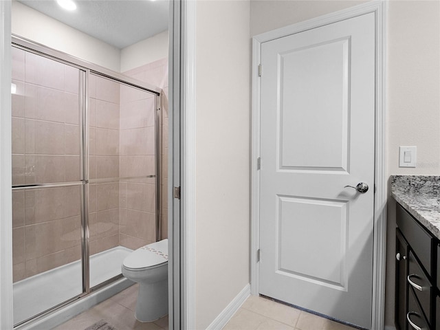 full bath with tile patterned floors, toilet, a shower stall, baseboards, and vanity