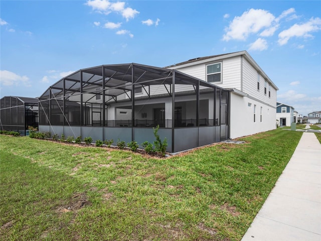 rear view of property with a lanai and a yard