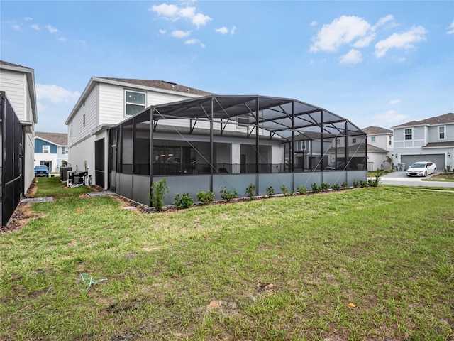 back of property with a lanai and a lawn