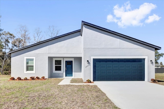 mid-century modern home featuring a front lawn, an attached garage, driveway, and stucco siding