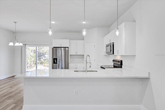 kitchen with white cabinetry, light countertops, appliances with stainless steel finishes, and a sink