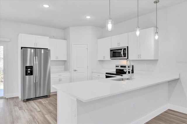 kitchen featuring a sink, stainless steel appliances, light wood-style floors, and light countertops