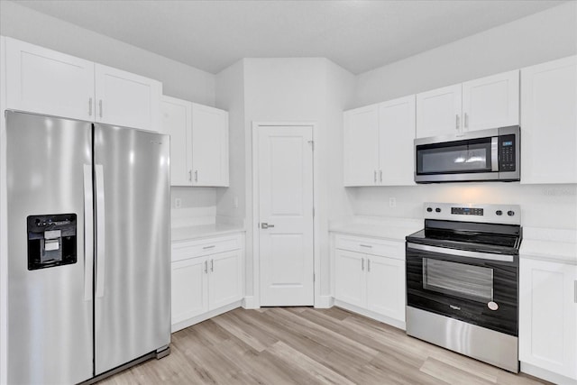 kitchen with light wood-style flooring, appliances with stainless steel finishes, white cabinetry, and light countertops