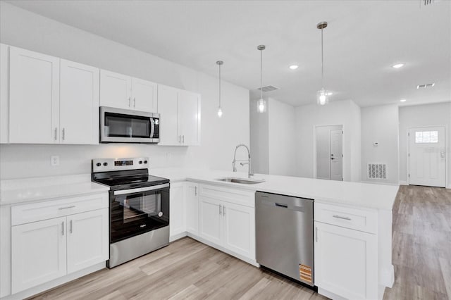 kitchen featuring a sink, a peninsula, visible vents, and stainless steel appliances