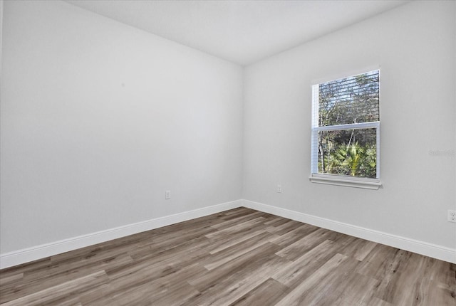 unfurnished room with baseboards and wood finished floors