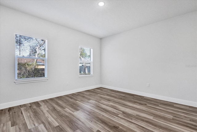 empty room with baseboards and wood finished floors