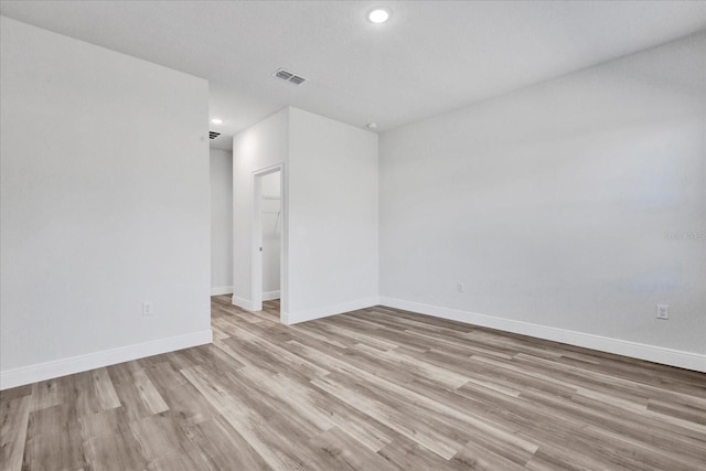 unfurnished room featuring recessed lighting, visible vents, light wood-style flooring, and baseboards