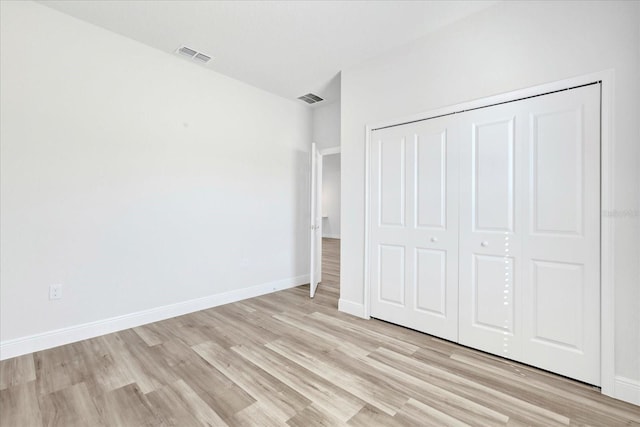 unfurnished bedroom with baseboards, visible vents, and light wood-type flooring