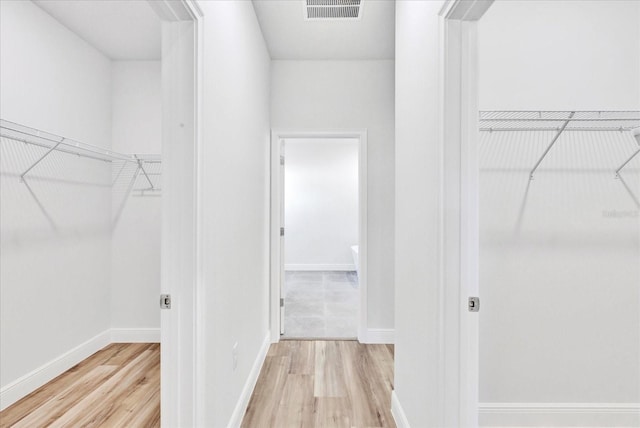 spacious closet featuring visible vents and wood finished floors