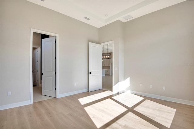 unfurnished bedroom featuring visible vents, baseboards, and light wood finished floors