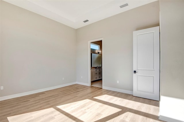 unfurnished bedroom with light wood finished floors, visible vents, and baseboards