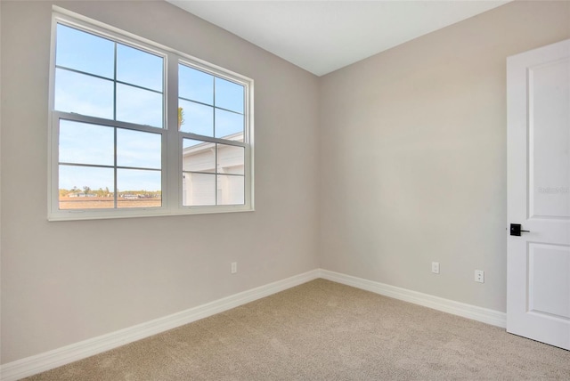 carpeted spare room with baseboards