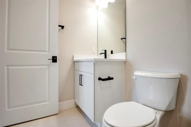 half bath featuring tile patterned flooring, toilet, vanity, and baseboards