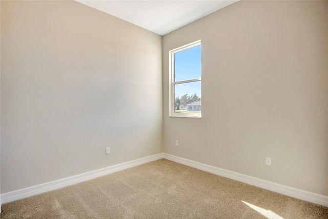 unfurnished room featuring baseboards and light colored carpet