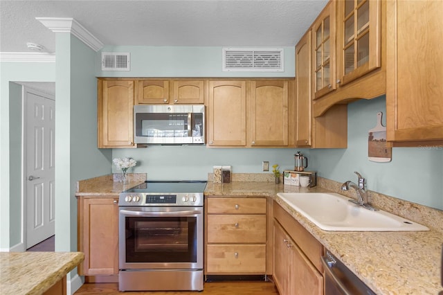 kitchen featuring a textured ceiling, visible vents, appliances with stainless steel finishes, and a sink