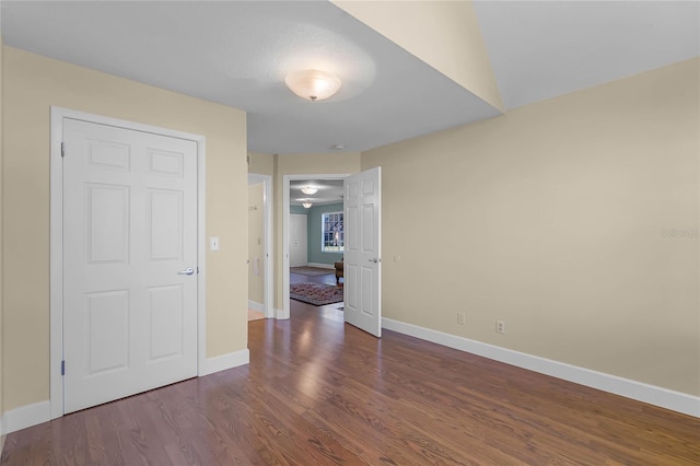 empty room with wood finished floors and baseboards