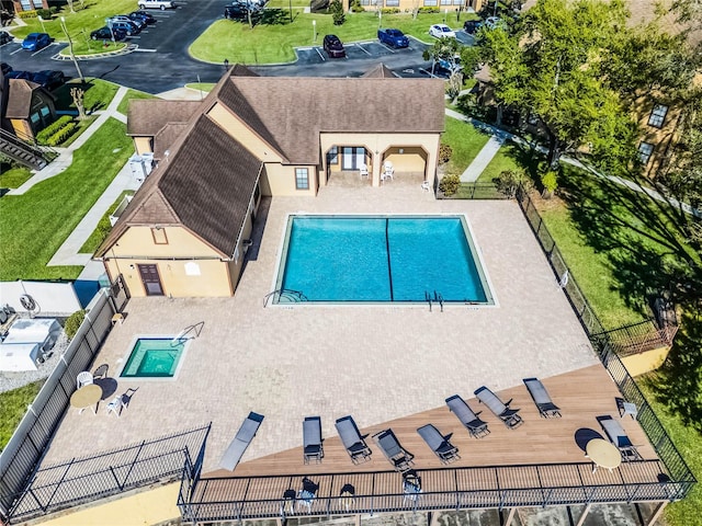 community pool with a patio and fence