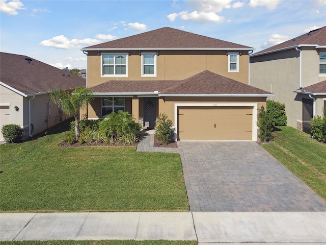 traditional home with a front lawn, decorative driveway, roof with shingles, and stucco siding