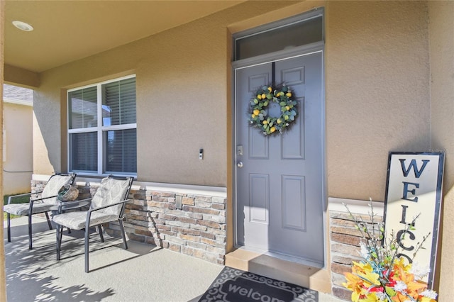 entrance to property featuring stucco siding and a porch