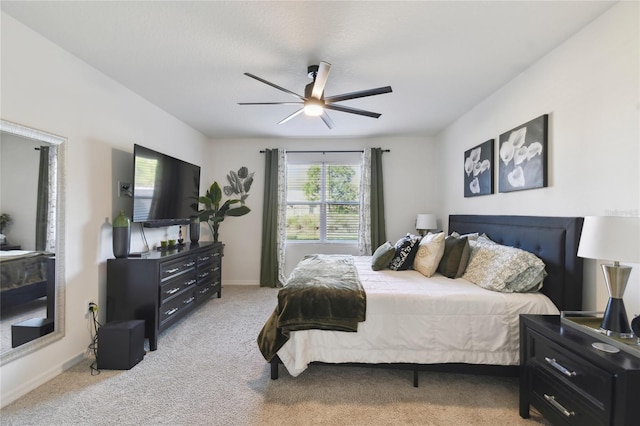 bedroom featuring baseboards, light colored carpet, and a ceiling fan