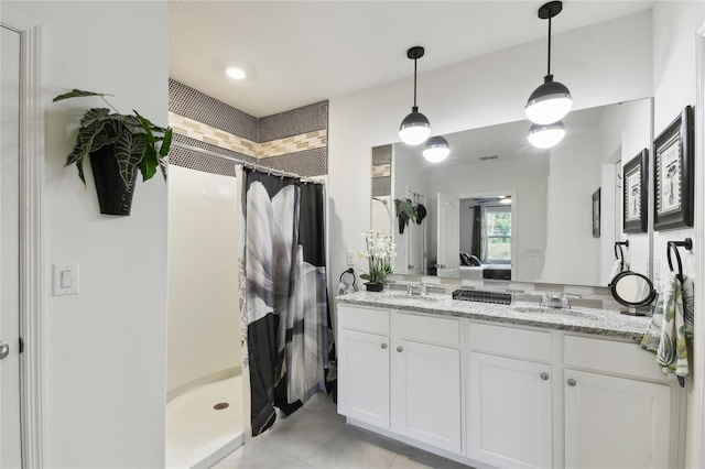 bathroom with a shower stall, double vanity, visible vents, and a sink