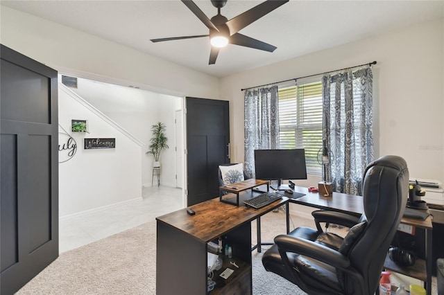 office space with light colored carpet, visible vents, a ceiling fan, and baseboards